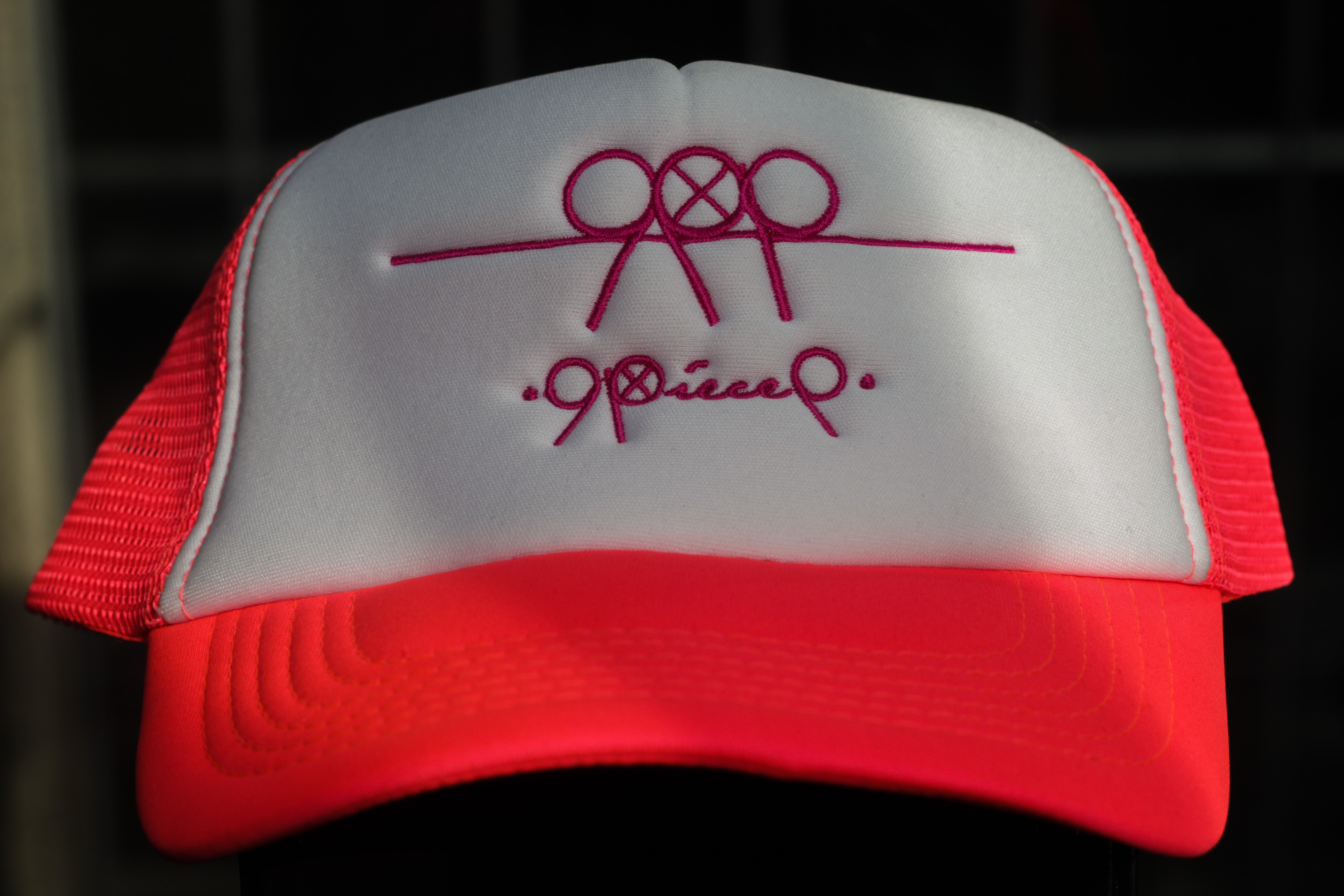 99Piece White & Pink Trucker Cap with adjustable snap.  100% Cotton (front panel and peak) & 100% Nylon mesh rear panels.